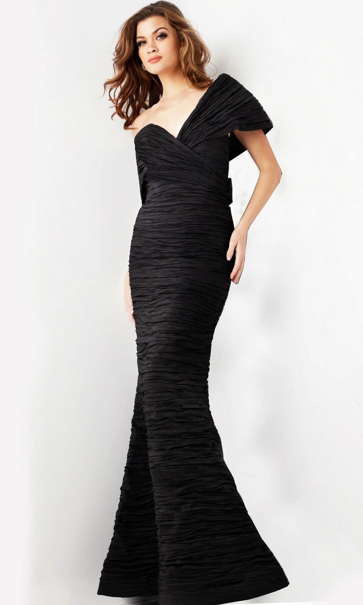 A woman wearing the Jovani 38954 Long Formal Dress, an off-shoulder evening gown with textured fabric and a form-fitting silhouette that accentuates her figure, stands against a white background.
